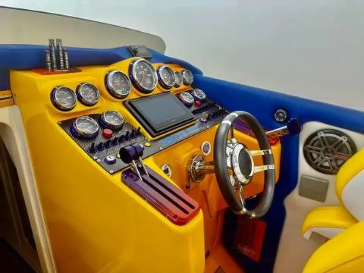 On Your Mark Yacht Photos Pics 2005 Cigarette 39 Top Gun boat dashboard with vibrant yellow and blue design, featuring gauges and controls.