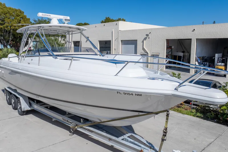  Yacht Photos Pics 2007 Intrepid 350 WA boat on trailer, parked outside a garage under clear blue sky.