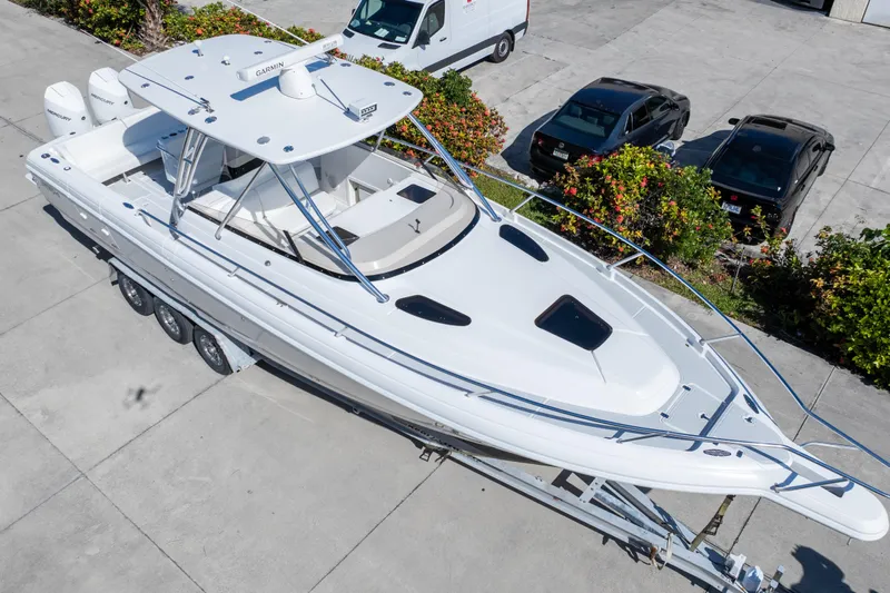  Yacht Photos Pics 2007 Intrepid 350 WA boat on trailer, parked near vehicles and greenery.