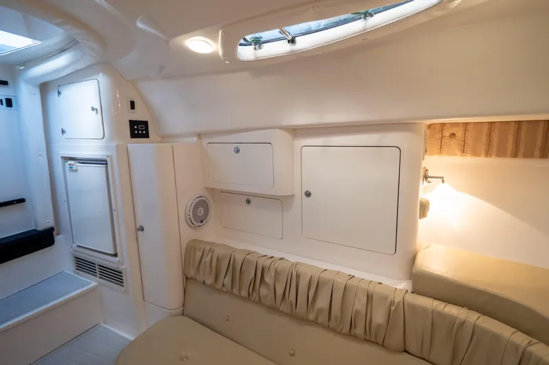  Yacht Photos Pics Interior of 2007 Intrepid 350 WA boat with beige seating and storage cabinets.