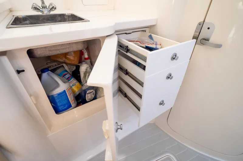  Yacht Photos Pics 2007 Intrepid 350 WA boat interior with open storage cabinet and sink.