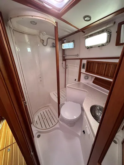 Limbo Yacht Photos Pics 2010 Sabre 40 Sedan yacht bathroom with shower, sink, and wooden accents.