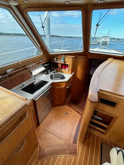 Limbo Yacht Photos Pics Interior of 2010 Sabre 40 Sedan yacht with wooden cabinetry and compact kitchen area.