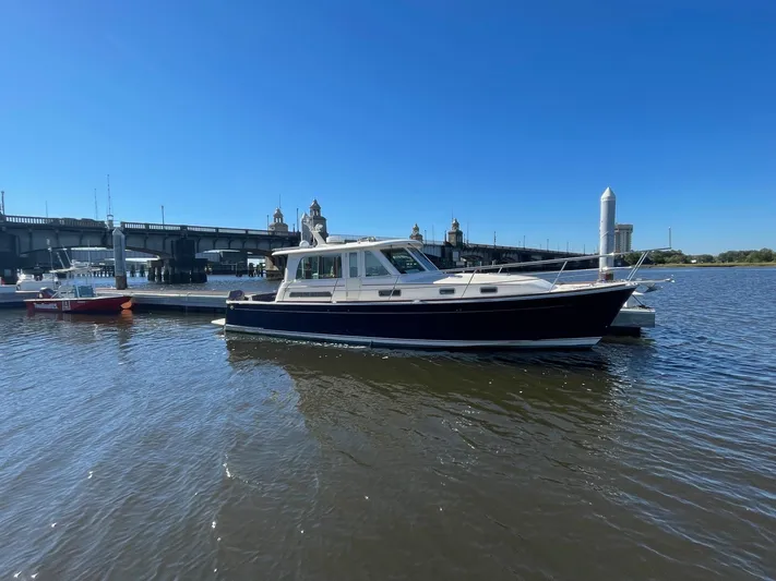 Limbo Yacht Photos Pics 2010 Sabre 40 Sedan boat docked near a bridge on a sunny day.