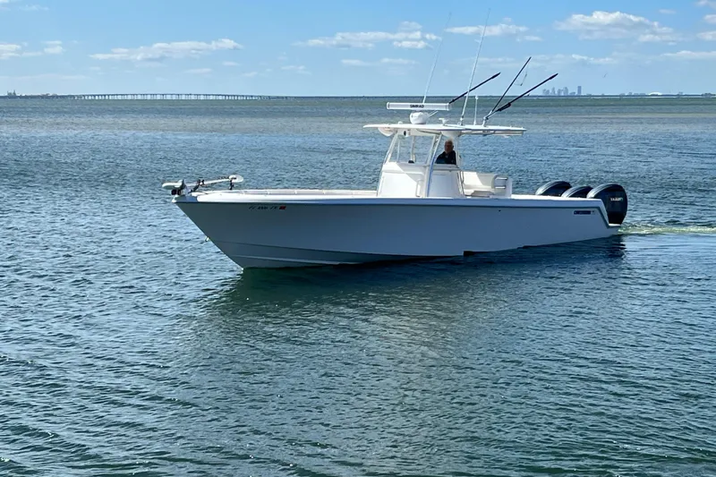  Yacht Photos Pics 2023 Contender 39 ST boat cruising on calm waters under a clear blue sky.