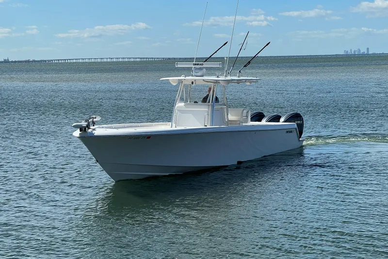  Yacht Photos Pics 2023 Contender 39 ST boat cruising on calm waters under a clear blue sky.