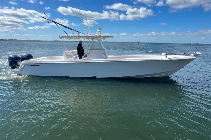  Yacht Photos Pics 2023 Contender 39 ST boat cruising on calm waters under a clear blue sky.