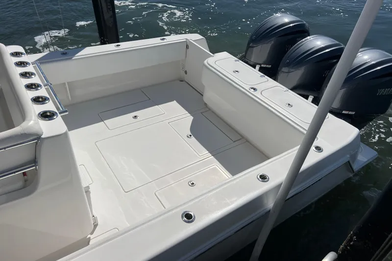  Yacht Photos Pics 2023 Contender 39 ST boat deck with triple outboard engines, docked on water.