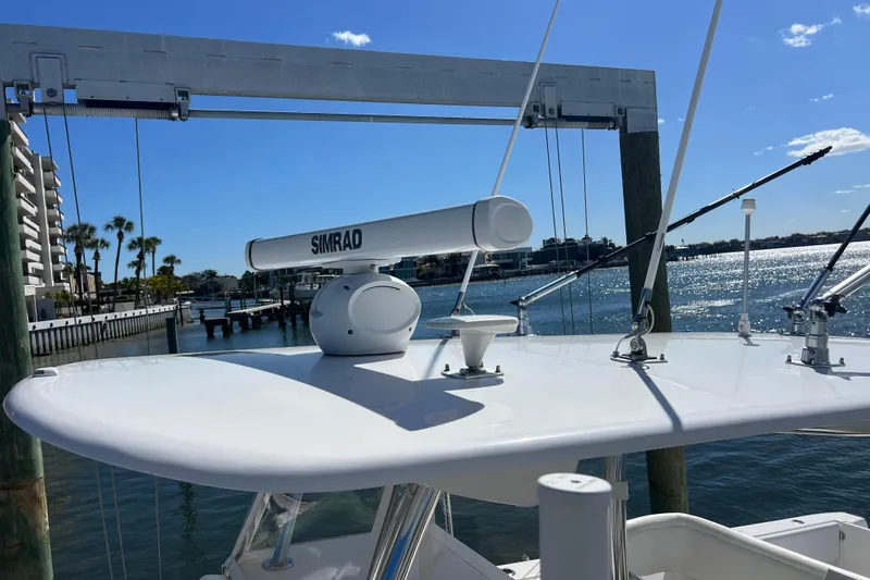  Yacht Photos Pics 2023 Contender 39 ST boat with Simrad radar, docked by waterfront under clear blue sky.