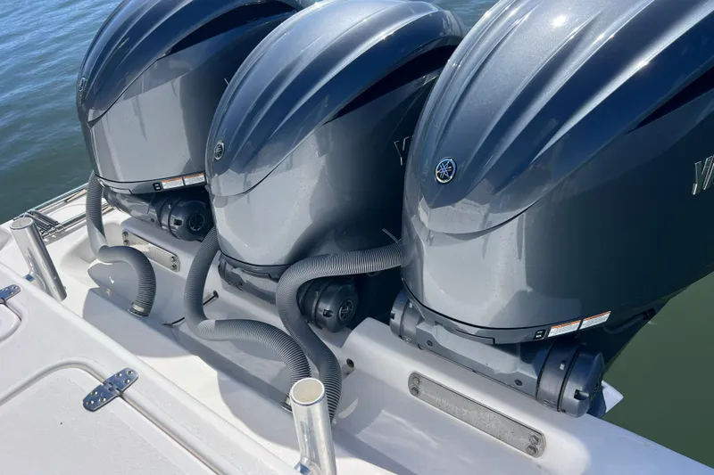  Yacht Photos Pics Triple outboard engines on a 2023 Contender 39 ST boat, docked on water.