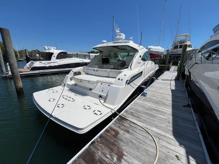 Feeling Nauti Yacht Photos Pics 2011 Sea Ray 470 Sundancer yacht docked at marina under clear blue sky.