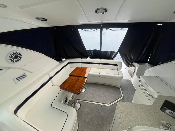 Feeling Nauti Yacht Photos Pics 2011 Sea Ray 470 Sundancer interior with white seating and wooden table.