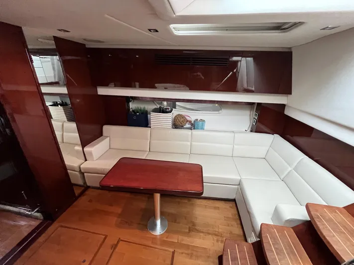 Feeling Nauti Yacht Photos Pics Luxurious interior of 2011 Sea Ray 470 Sundancer yacht with white leather seating and wooden table.
