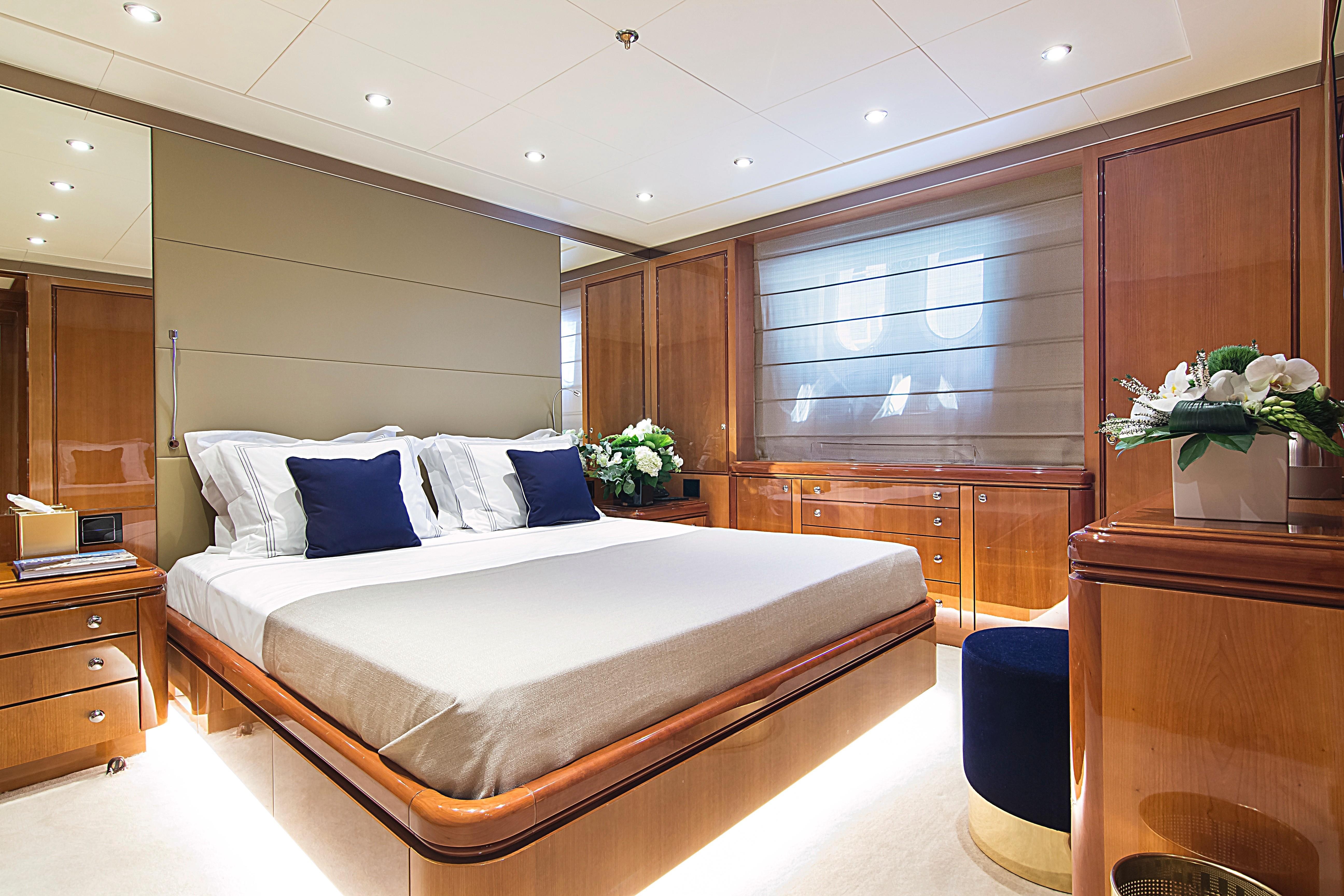 Luxurious bedroom interior on 1999 Codecasa 50m Motoryacht with elegant wood finishes.