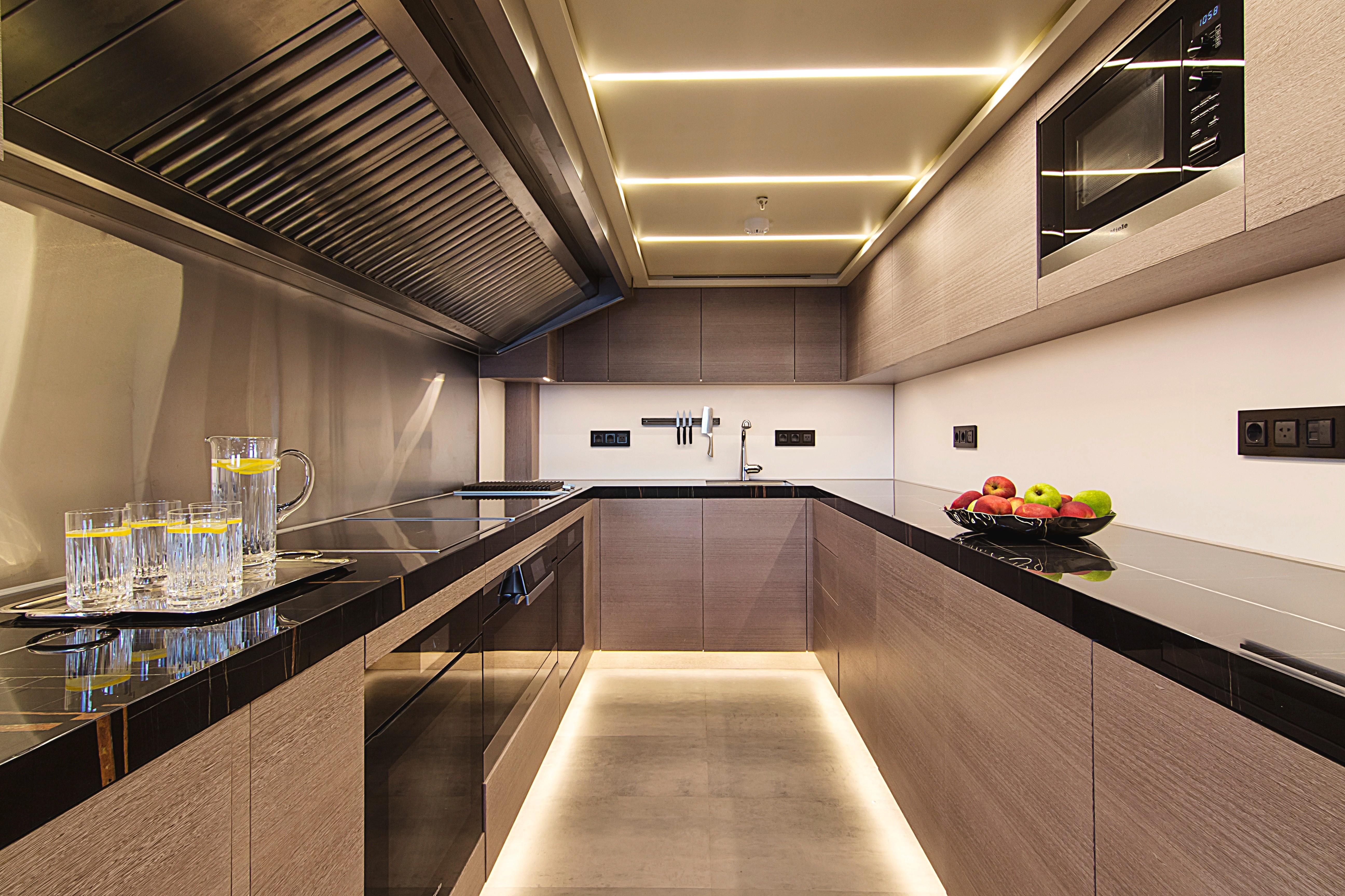 Modern kitchen interior on 1999 Codecasa 50m Motoryacht, featuring sleek cabinetry and ambient lighting.