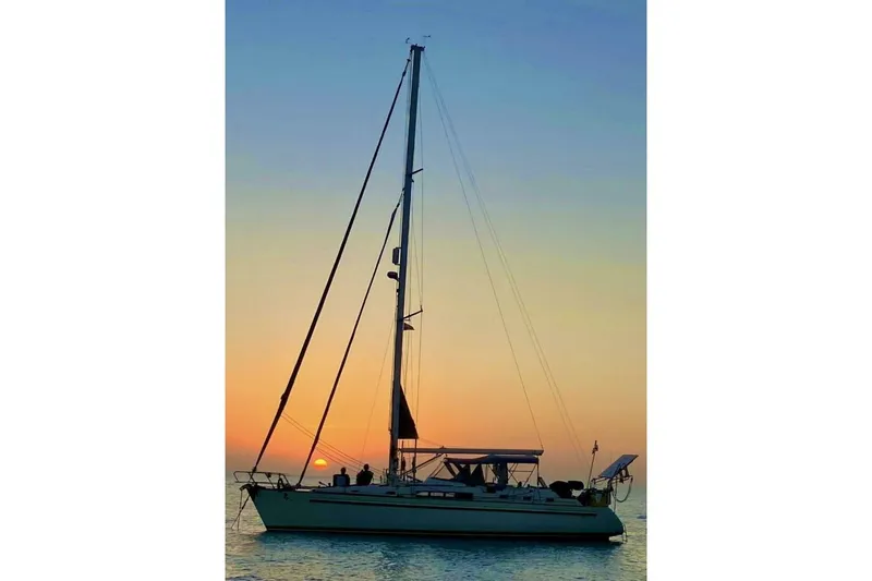 Waterfall II Yacht Photos Pics Sailboat Beneteau Oceanis 44 CC 1994 at sunset on calm sea.