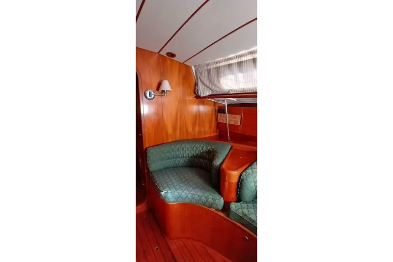 Waterfall II Yacht Photos Pics Interior of 1994 Beneteau Oceanis 44 CC yacht with green seating and wooden paneling.