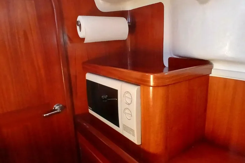 Waterfall II Yacht Photos Pics Wooden interior of 1994 Beneteau Oceanis 44 CC with microwave and paper towel holder.