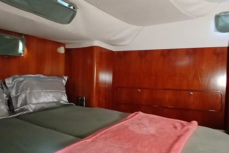 Waterfall II Yacht Photos Pics Cozy cabin interior of 1994 Beneteau Oceanis 44 CC sailboat with wood paneling and bedding.