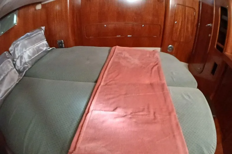 Waterfall II Yacht Photos Pics Cozy cabin interior of 1994 Beneteau Oceanis 44 CC with double bed and wooden finish.