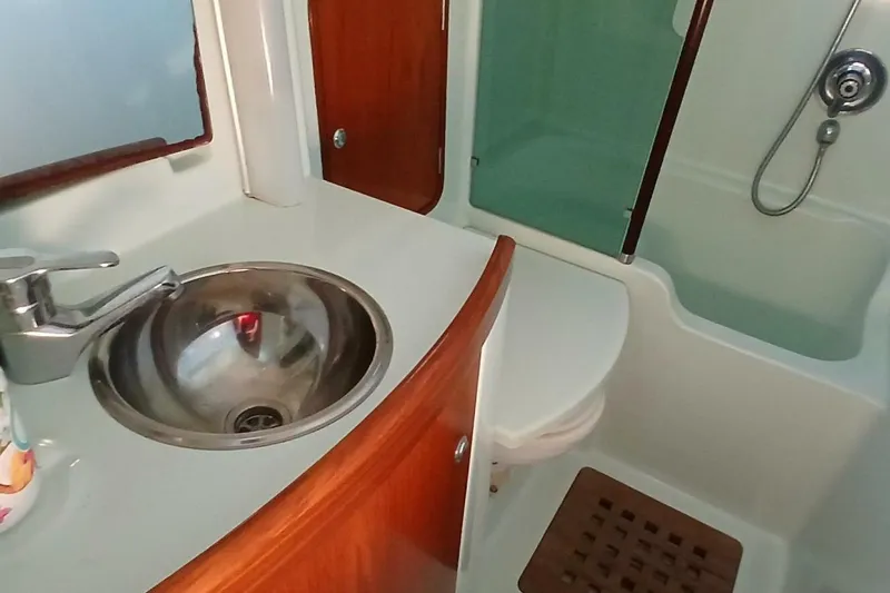 Waterfall II Yacht Photos Pics Bathroom interior of 1994 Beneteau Oceanis 44 CC yacht, featuring sink and shower.