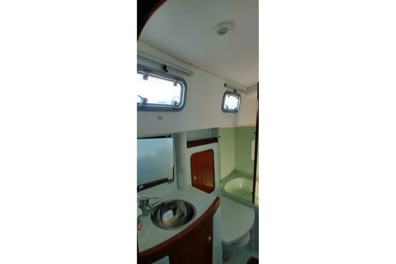 Waterfall II Yacht Photos Pics Interior of 1994 Beneteau Oceanis 44 CC yacht bathroom with sink and portholes.