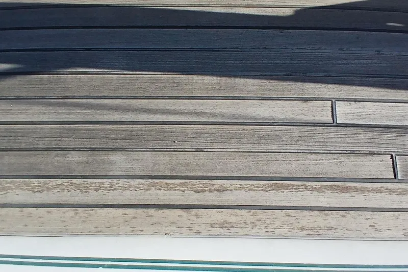Waterfall II Yacht Photos Pics Teak deck of 1994 Beneteau Oceanis 44 CC sailboat, showing weathered wood planks.