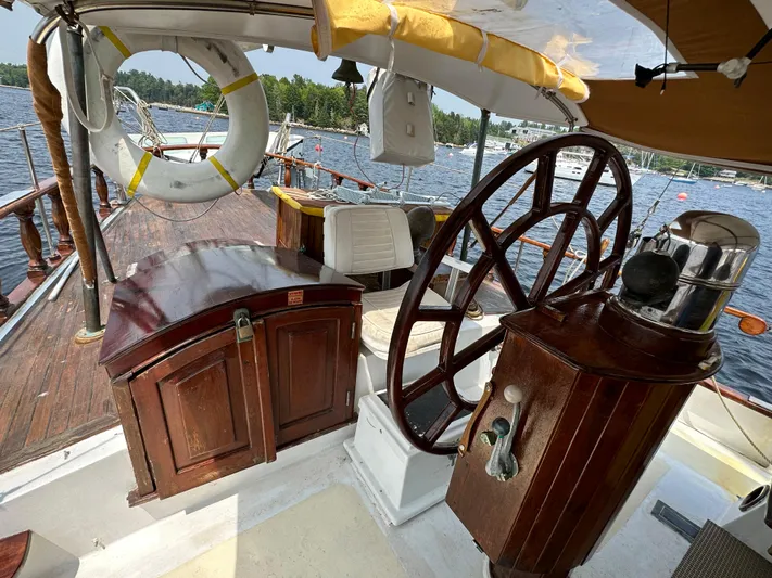 Interlude X Yacht Photos Pics Vintage 1985 Thomas Colvin "Pipistrelle" sailboat interior with wooden helm and nautical decor.