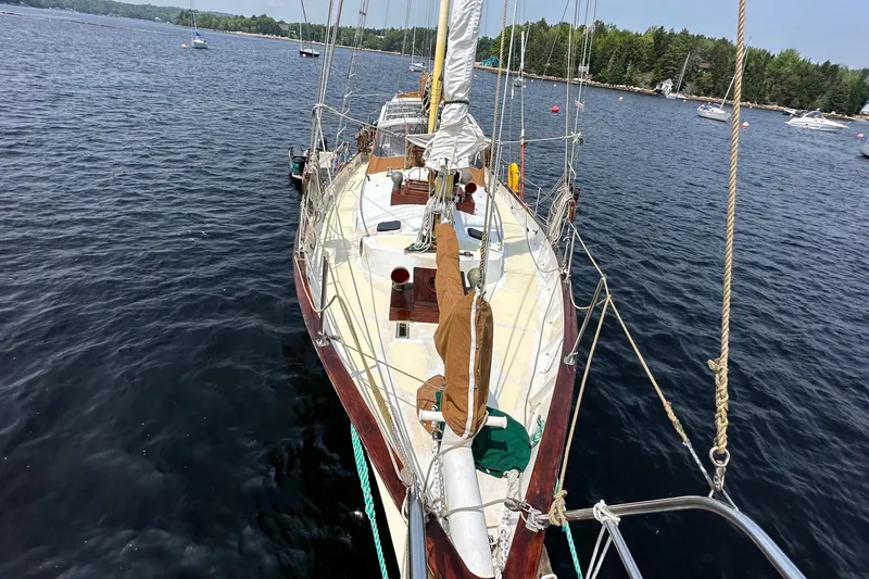 Interlude X Yacht Photos Pics Sailboat on calm lake, Custom Thomas Colvin "Pipistrelle" model, 1985, surrounded by lush greenery.