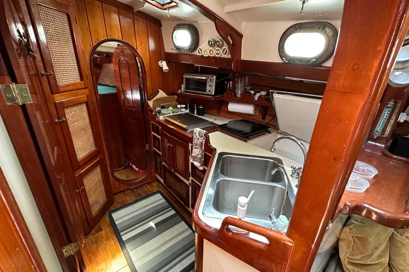 Interlude X Yacht Photos Pics Cozy 1985 Thomas Colvin "Pipistrelle" yacht interior with wooden cabinetry and compact kitchen.