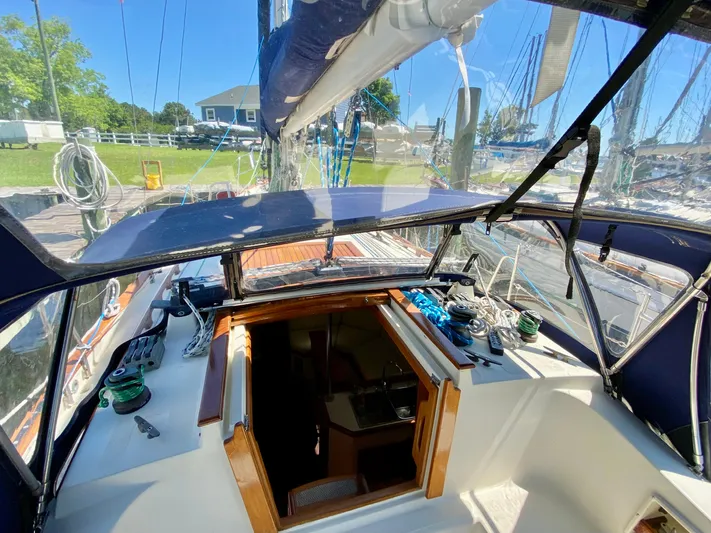 Encore Yacht Photos Pics Cockpit view of a 1998 Pacific Seacraft 37 sailboat with open hatch and clear canopy.