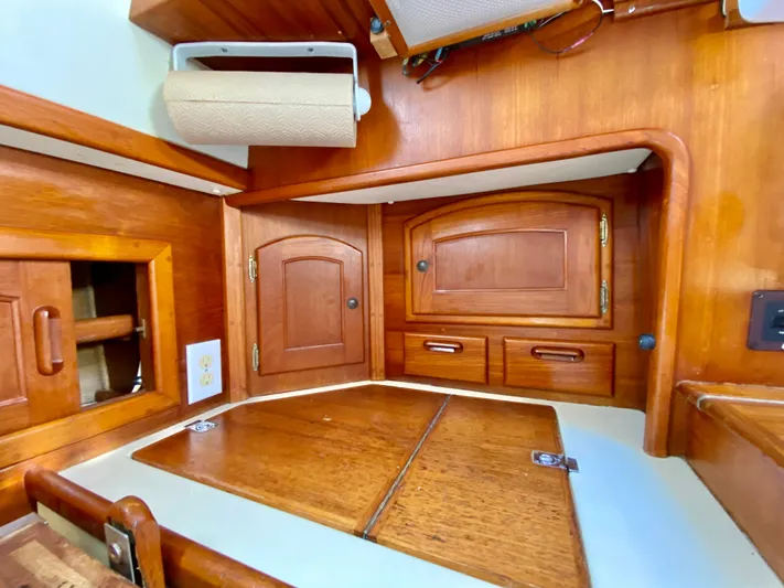 Encore Yacht Photos Pics Interior of 1998 Pacific Seacraft 37 sailboat with wooden cabinetry and storage compartments.