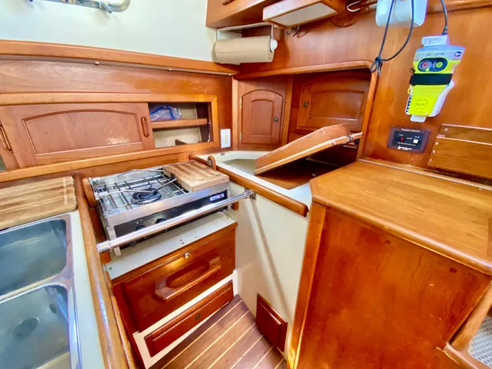Encore Yacht Photos Pics Interior of 1998 Pacific Seacraft 37 sailboat galley with wooden cabinetry and stove.