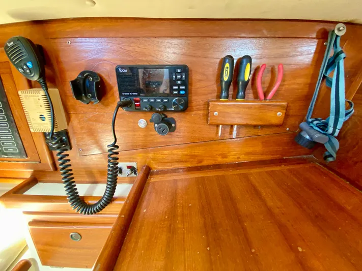 Encore Yacht Photos Pics Navigation station of 1998 Pacific Seacraft 37 with radio, tools, and wooden paneling.