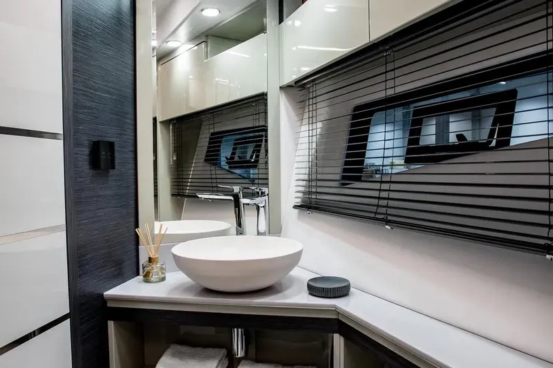  Yacht Photos Pics Luxurious bathroom interior of 2025 Cobrey 45 FLY yacht with modern sink and window blinds.