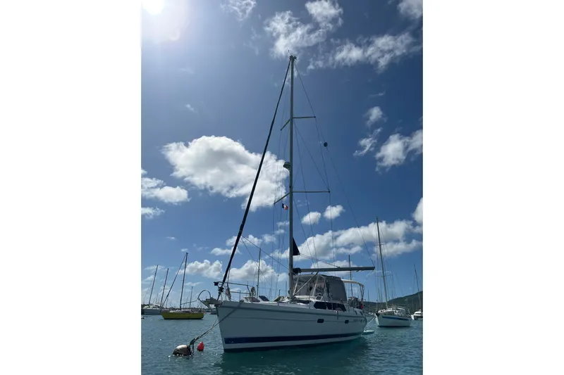 Pelagia Yacht Photos Pics Sailboat Hunter Passage 450, 1998 model, anchored under a sunny sky with scattered clouds.