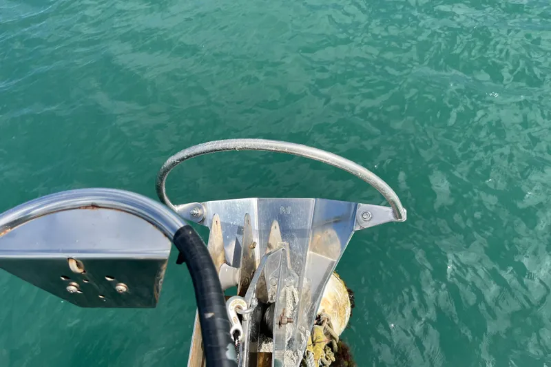 Pelagia Yacht Photos Pics Bow of 1998 Hunter Passage 450 sailboat with anchor over turquoise water.