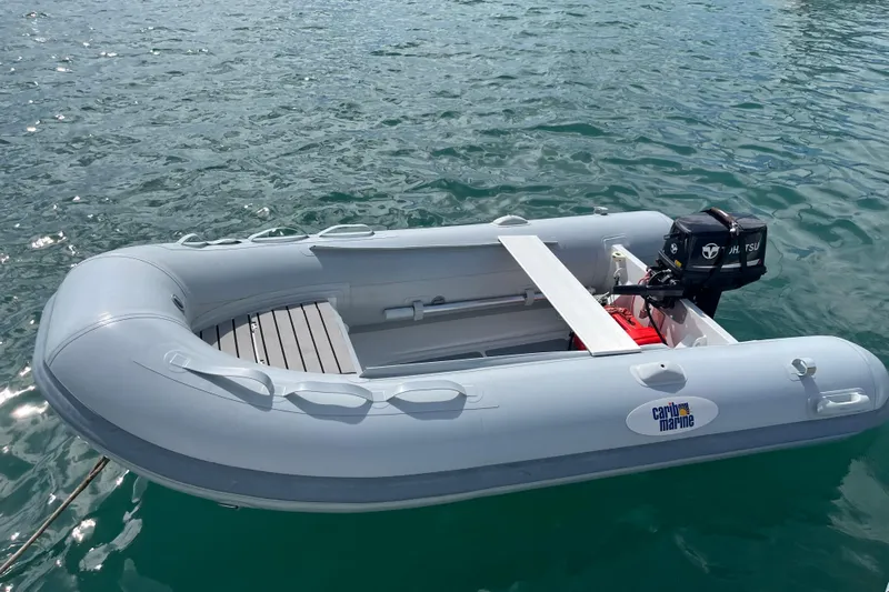 Pelagia Yacht Photos Pics Inflatable boat with outboard motor on calm water, featuring Caribe Marine branding.