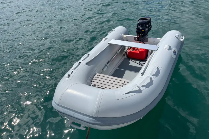 Pelagia Yacht Photos Pics Inflatable boat on water, featuring an outboard motor and red fuel tank.