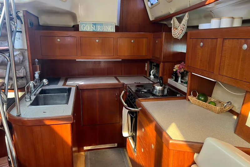 Pelagia Yacht Photos Pics Interior of 1998 Hunter Passage 450 yacht kitchen with wooden cabinetry and modern amenities.