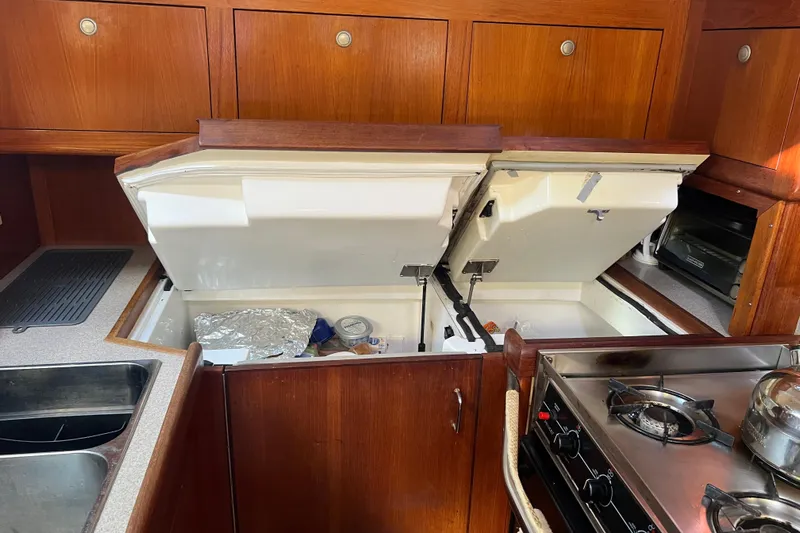 Pelagia Yacht Photos Pics Galley kitchen in 1998 Hunter Passage 450 yacht with open storage compartments.