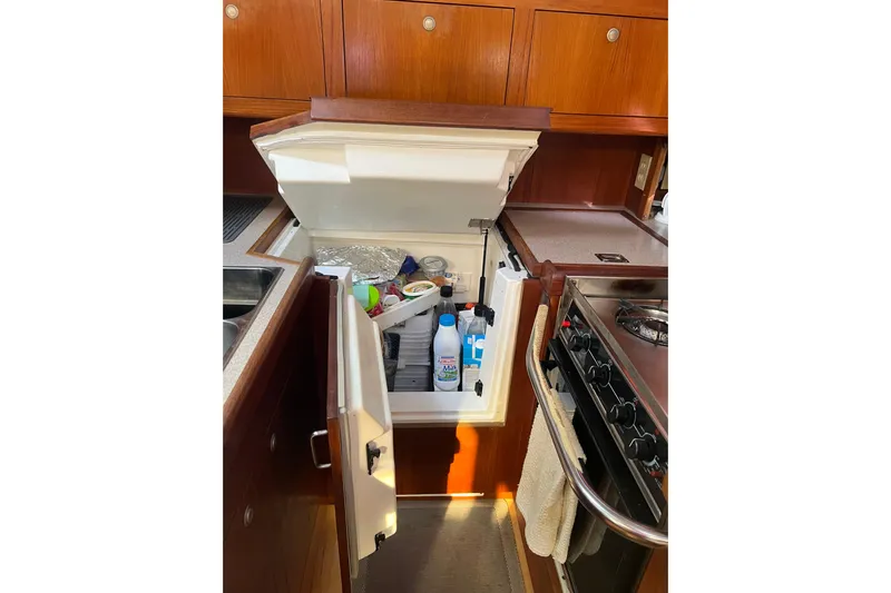 Pelagia Yacht Photos Pics Galley kitchen of 1998 Hunter Passage 450 yacht with open fridge and stove.