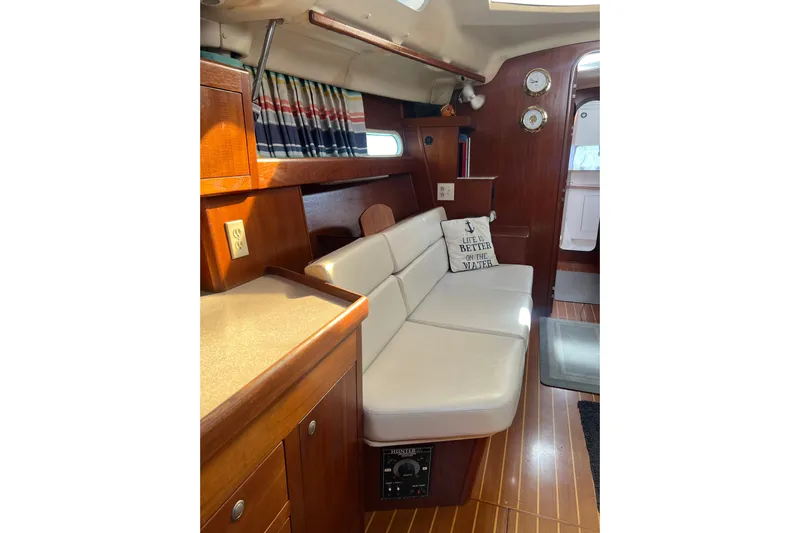 Pelagia Yacht Photos Pics Interior of 1998 Hunter Passage 450 yacht with cozy seating and nautical decor.