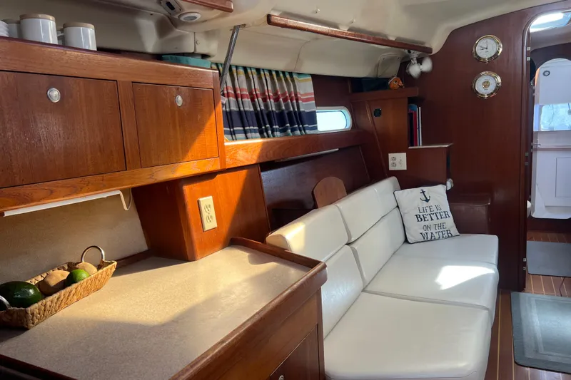 Pelagia Yacht Photos Pics Interior of 1998 Hunter Passage 450 yacht with cozy seating and wooden cabinetry.