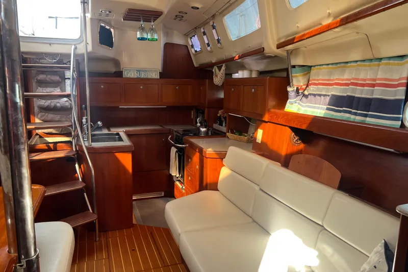 Pelagia Yacht Photos Pics Interior of 1998 Hunter Passage 450 yacht with cozy seating and wooden cabinetry.