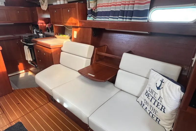 Pelagia Yacht Photos Pics Interior of 1998 Hunter Passage 450 yacht with cozy seating and nautical decor.