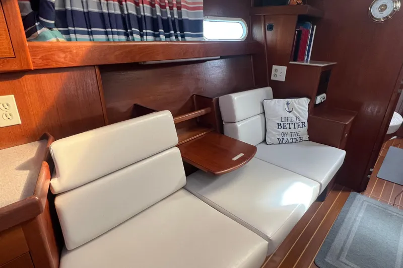 Pelagia Yacht Photos Pics Interior of 1998 Hunter Passage 450 yacht with white seating and nautical decor.