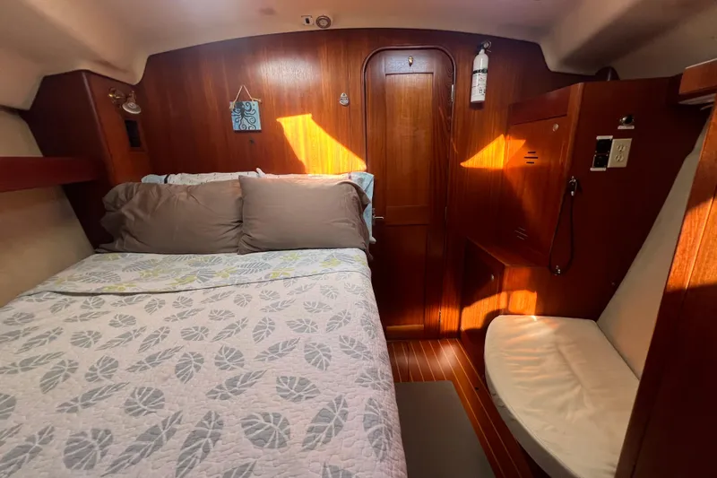 Pelagia Yacht Photos Pics Cozy cabin interior of 1998 Hunter Passage 450 sailboat with wooden paneling and bed.
