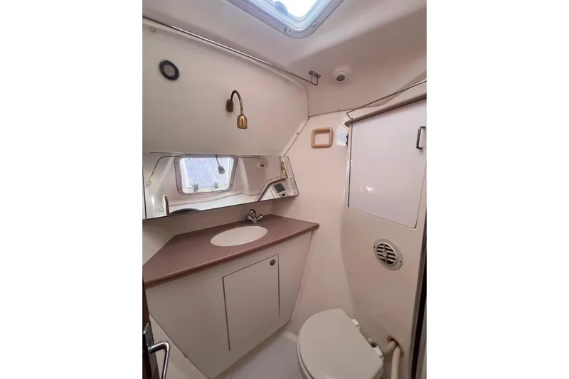 Pelagia Yacht Photos Pics Bathroom interior of 1998 Hunter Passage 450 yacht, featuring sink, mirror, and toilet.