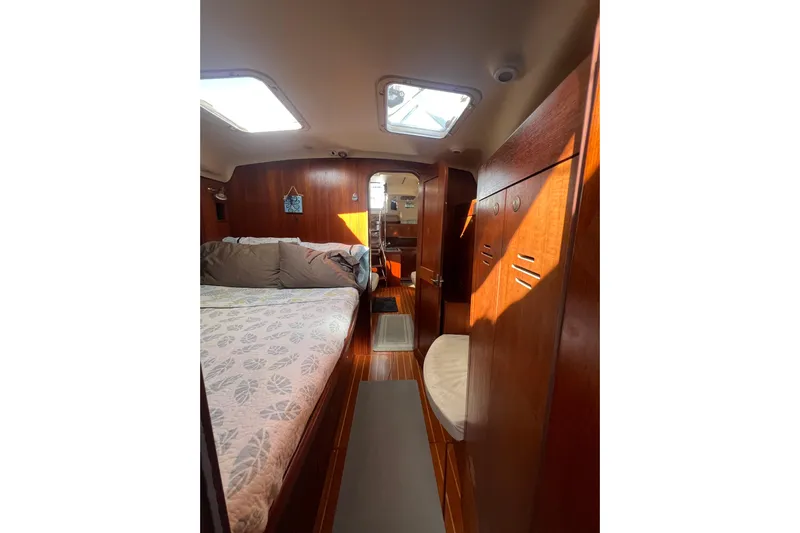 Pelagia Yacht Photos Pics 1998 Hunter Passage 450 yacht interior with cozy bed and wooden cabinetry.